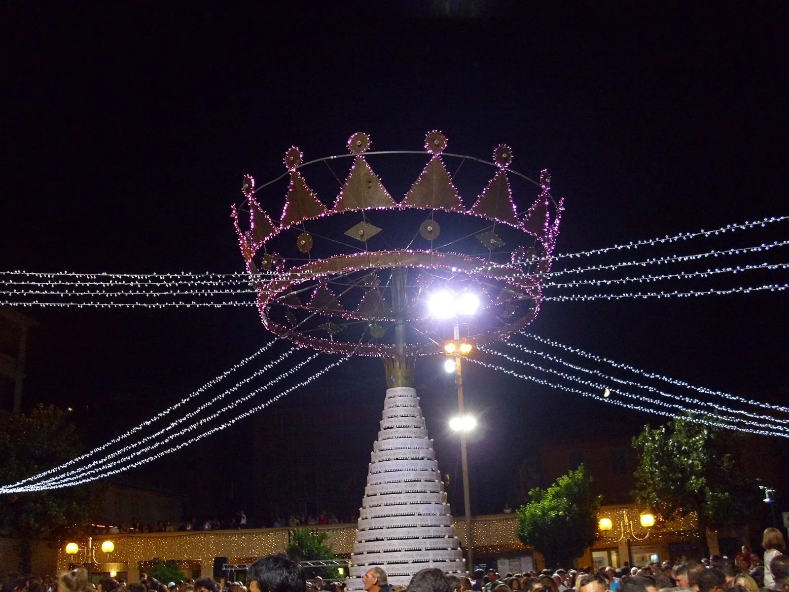 La grande torta a piani sormontata da una corona illuminata nella piazza di Lavagna durante la festa della Torta dei Fieschi